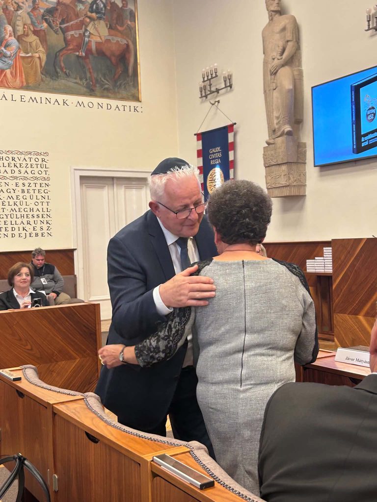 prof. Dr. Grósz Andor elnök úr virágcsokorral köszöntötte a teremben jelen lévő Jávor Mátyásné (Zsuzsika nénit)